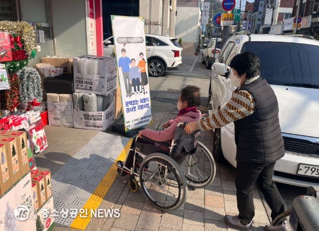 이동식 경사로 무료 지원’ 장애인 이동권 확보_주민들이 이동식 경사로를 이용하여 상가로 들어가고 있다