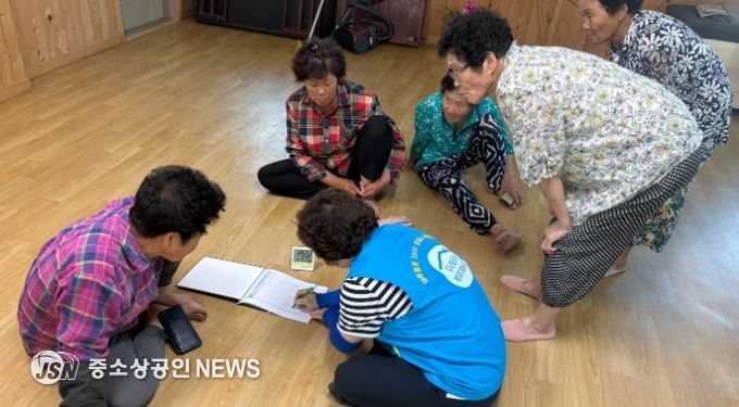 강진군 작천면 복지기동대원이 경로당 어르신에게 온·습도계를 배부하며 관리대장 작성법을 설명하고 있다.