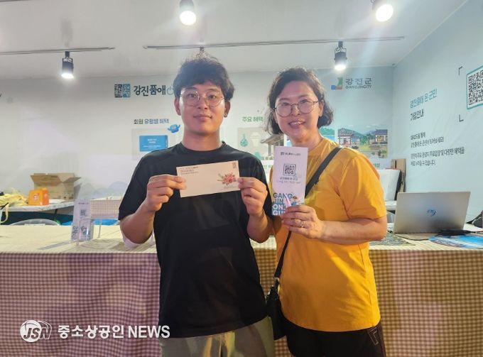 하맥축제 현장 뽑기이벤트 당첨자가 강진사랑상품권을 들고 기념촬영을 하고 있다