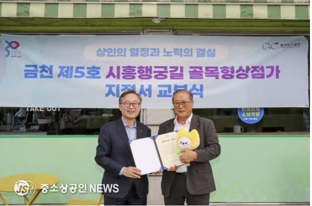 유성훈 금천구청장(왼쪽)과 김명식 상인회장이 골목형상점가 지정서 교부식을 진행하고 기념촬영을 하고 있다